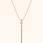 Gold-tone Y-shaped necklace with a fine oval-link chain, two floral charms and a long drop of clear round accents.