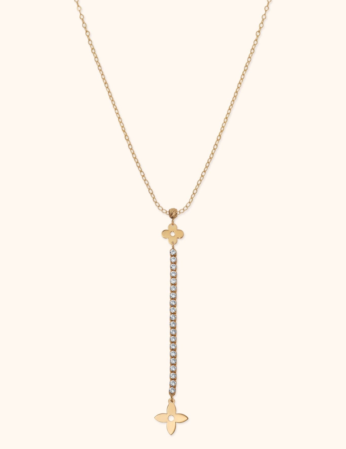 Gold-tone Y-shaped necklace with a fine oval-link chain, two floral charms and a long drop of clear round accents.
