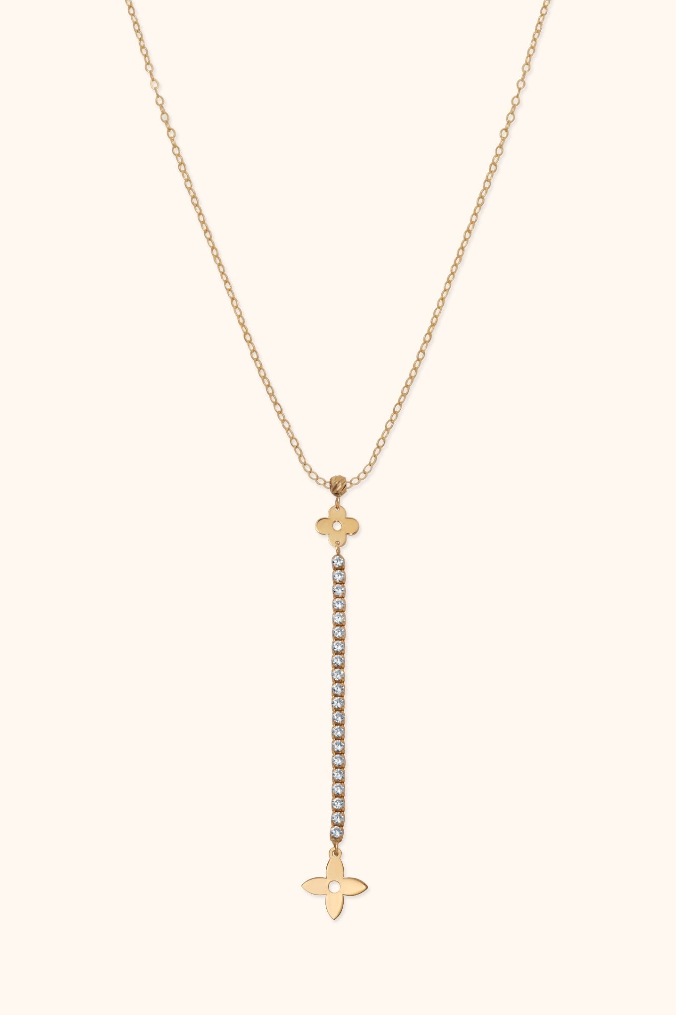 Gold-tone Y-shaped necklace with a fine oval-link chain, two floral charms and a long drop of clear round accents.