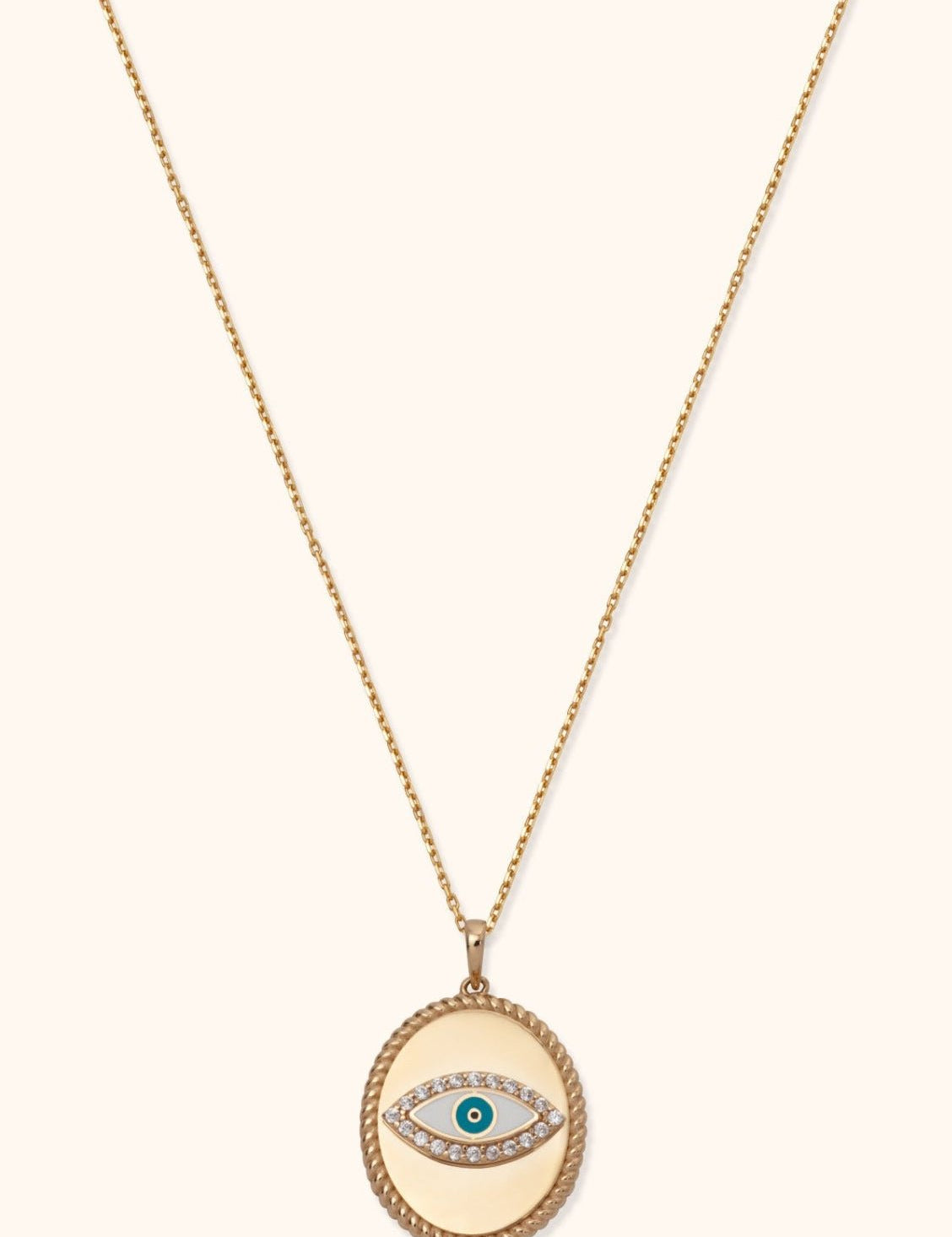 Gold-tone chain necklace with an oval pendant, rope-style border and teal-centered eye motif outlined in clear sparkling accents.