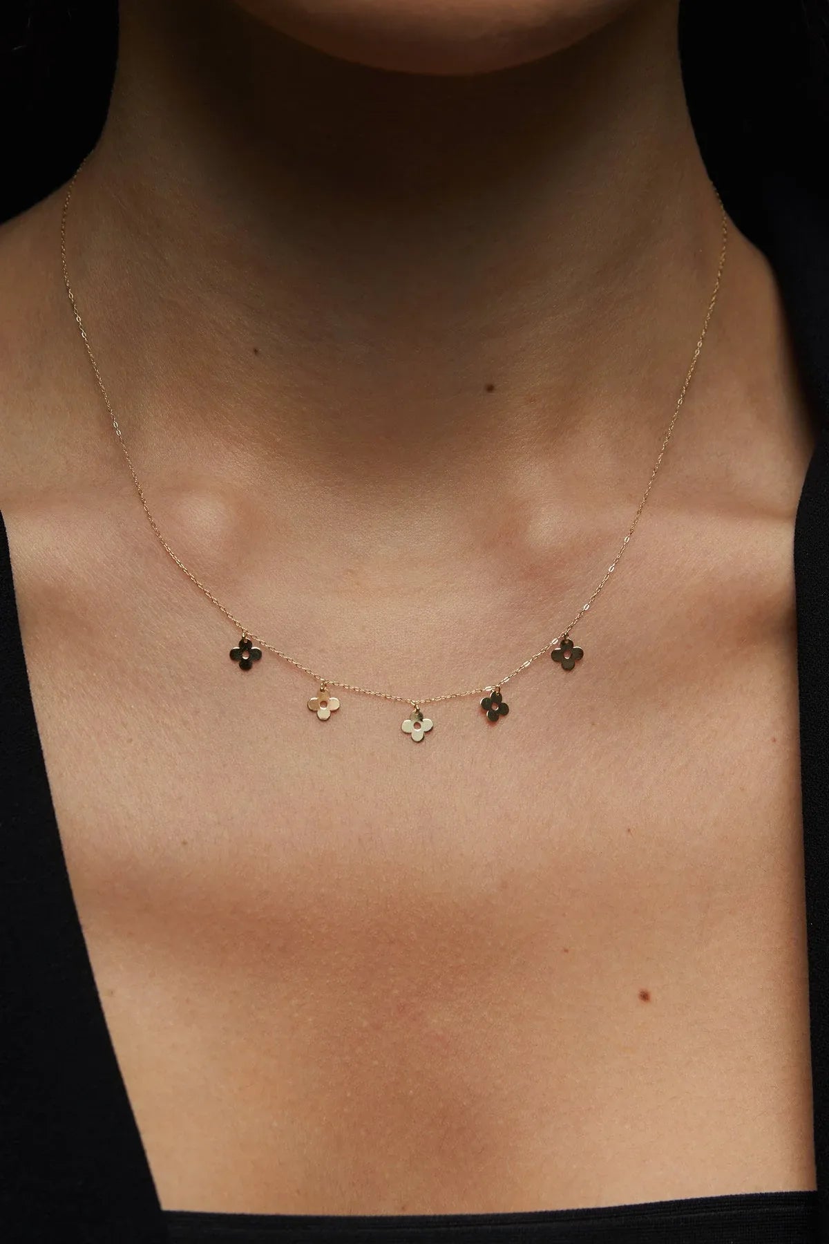 14K gold necklace featuring multiple four-leaf clover charms,