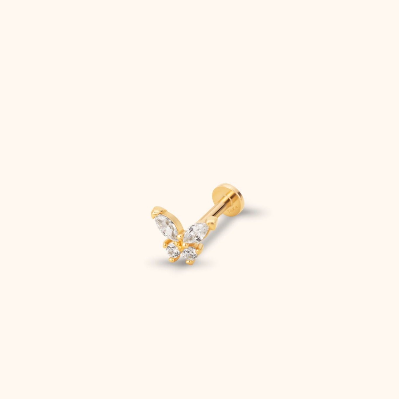 Gold-tone butterfly stud earring with four clear stones, a straight post and a flat round back on a pale cream background.