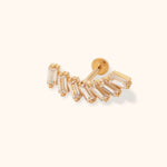 Gold-tone stud with clear rectangular stones arranged in a curved fan, a straight post and round flat back on a cream background.
