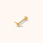 Gold-colored lightning bolt stud with a straight post and round flat back, shown diagonally on a pale cream background.