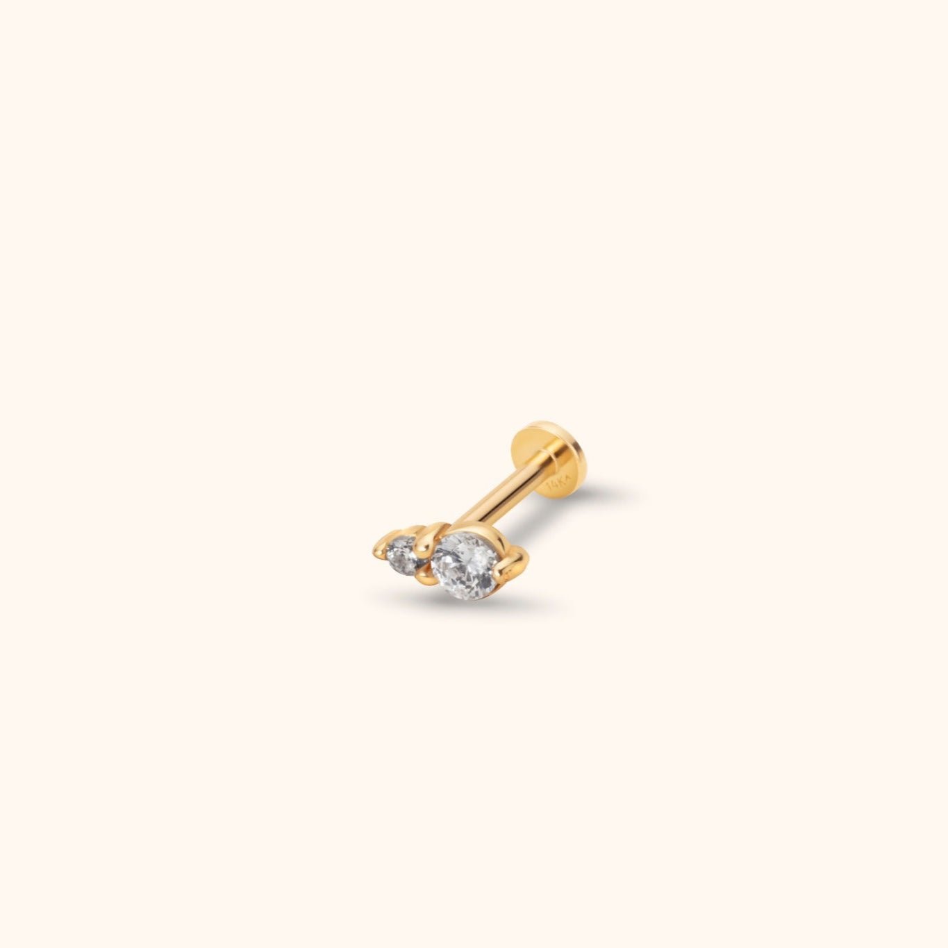Gold-toned stud with two clear round stones of different sizes, prong settings, a straight post and a flat circular back.