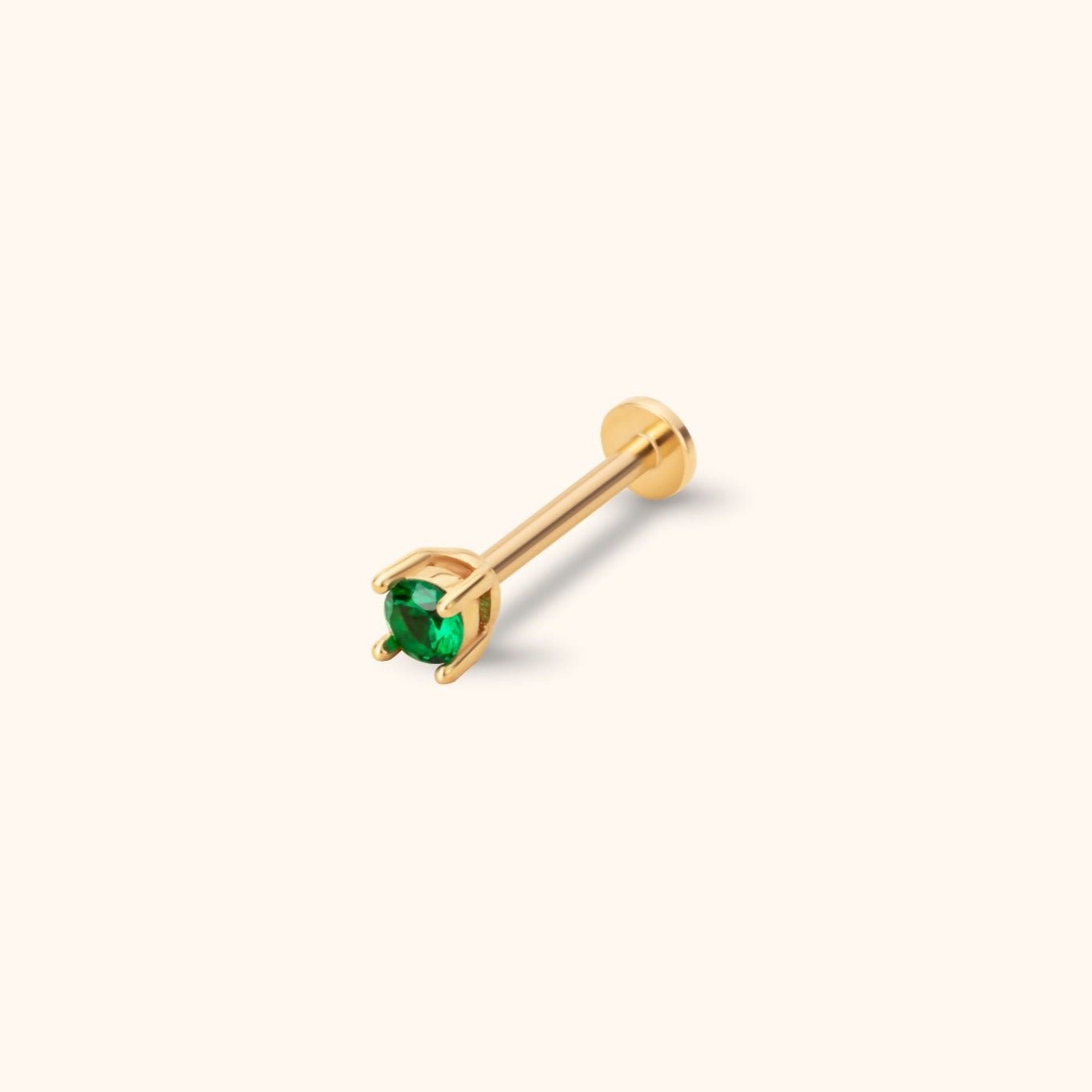 Gold-toned stud with a round green faceted center in a prong setting, a straight post and a flat circular back on a cream background.