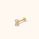 Gold-toned stud with a clear oval faceted center in a four-prong setting, a straight post and a flat round back on a cream background.