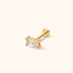 Gold-toned stud earring with a clear rectangular faceted stone, straight post and round flat back on a cream background.