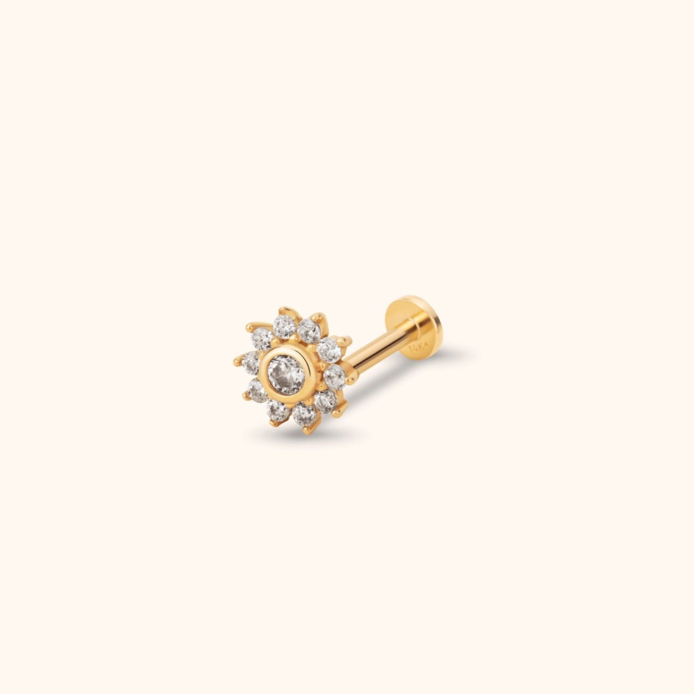 Gold-colored flower stud earring with a clear round center and smaller clear accents, a straight post and flat circular back.