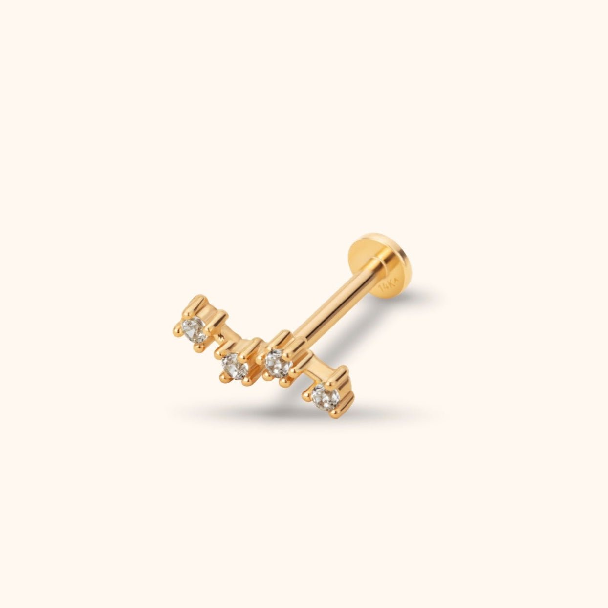 Gold-toned piercing stud with four clear round stones in a staggered bar, a straight post and a flat circular back.