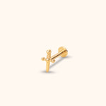 Gold-toned sword stud earring with a ridged handle, rounded crossguard ends and flat disc back on a cream background.