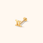 Gold-colored stud with a Gemini symbol front, straight post and round flat back, shown at an angle on a pale cream background.