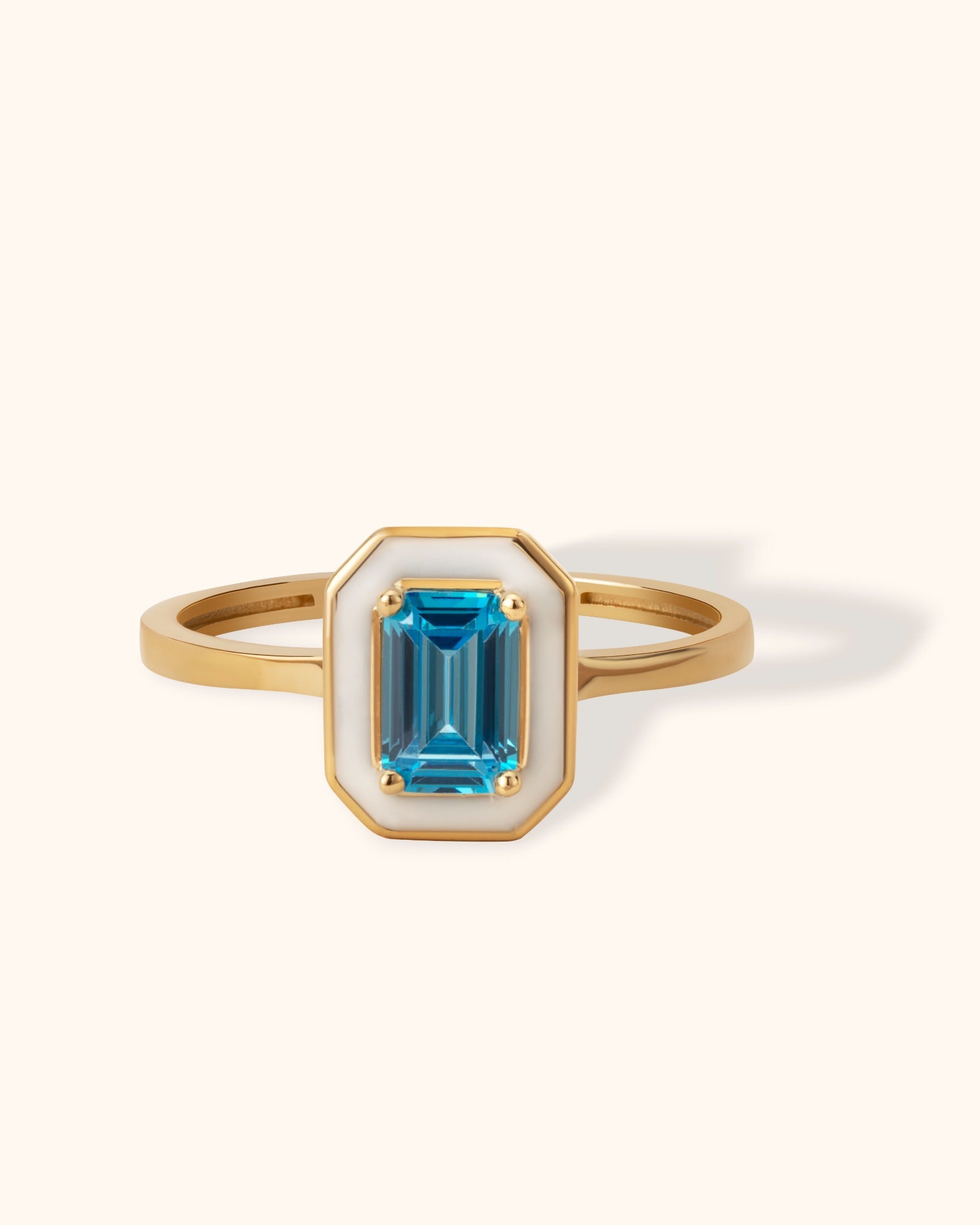 14K gold ring with emerald-cut blue topaz framed by white enamel