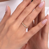 Elegant gold ring with clustered baguette-cut diamonds, worn on a woman's hand with light pink manicure, paired with a white turtleneck for a refined and minimal look.

