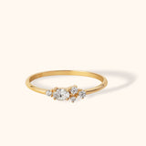 Delicate 14K gold ring featuring an oval-cut center diamond and clustered side stones