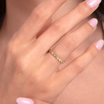 Close-up of a woman's hand wearing a 14K gold star eternity ring with polished pink nails, showcasing the celestial design.