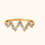 14K gold chevron ring featuring round and baguette-cut diamonds in a crown-like design