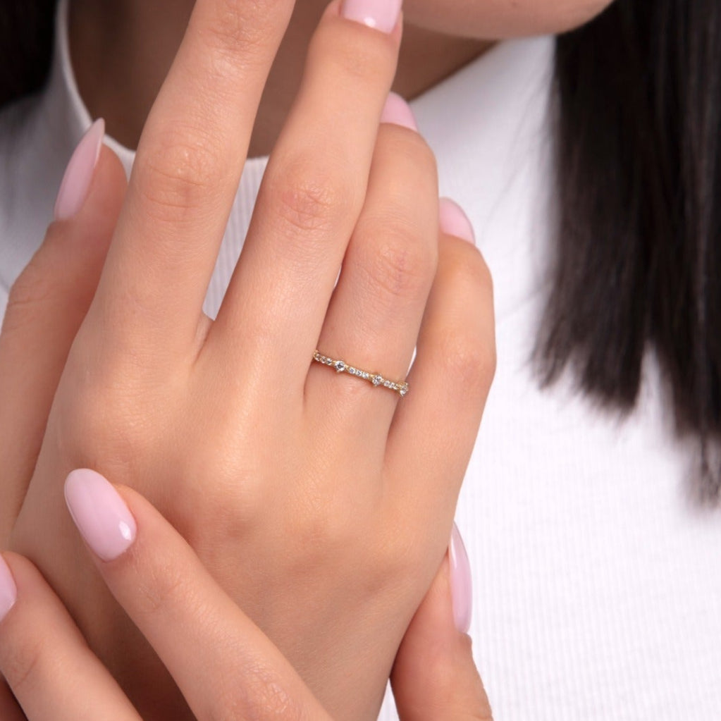 Thin gold ring with dainty sparkle stones worn on hand – perfect for stacking or wearing alone