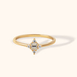 14K gold ring with baguette center stone and four round diamonds in a diamond-shaped setting