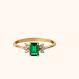 Elegant 14K gold ring with emerald-cut green gemstone and diamond floral side clusters