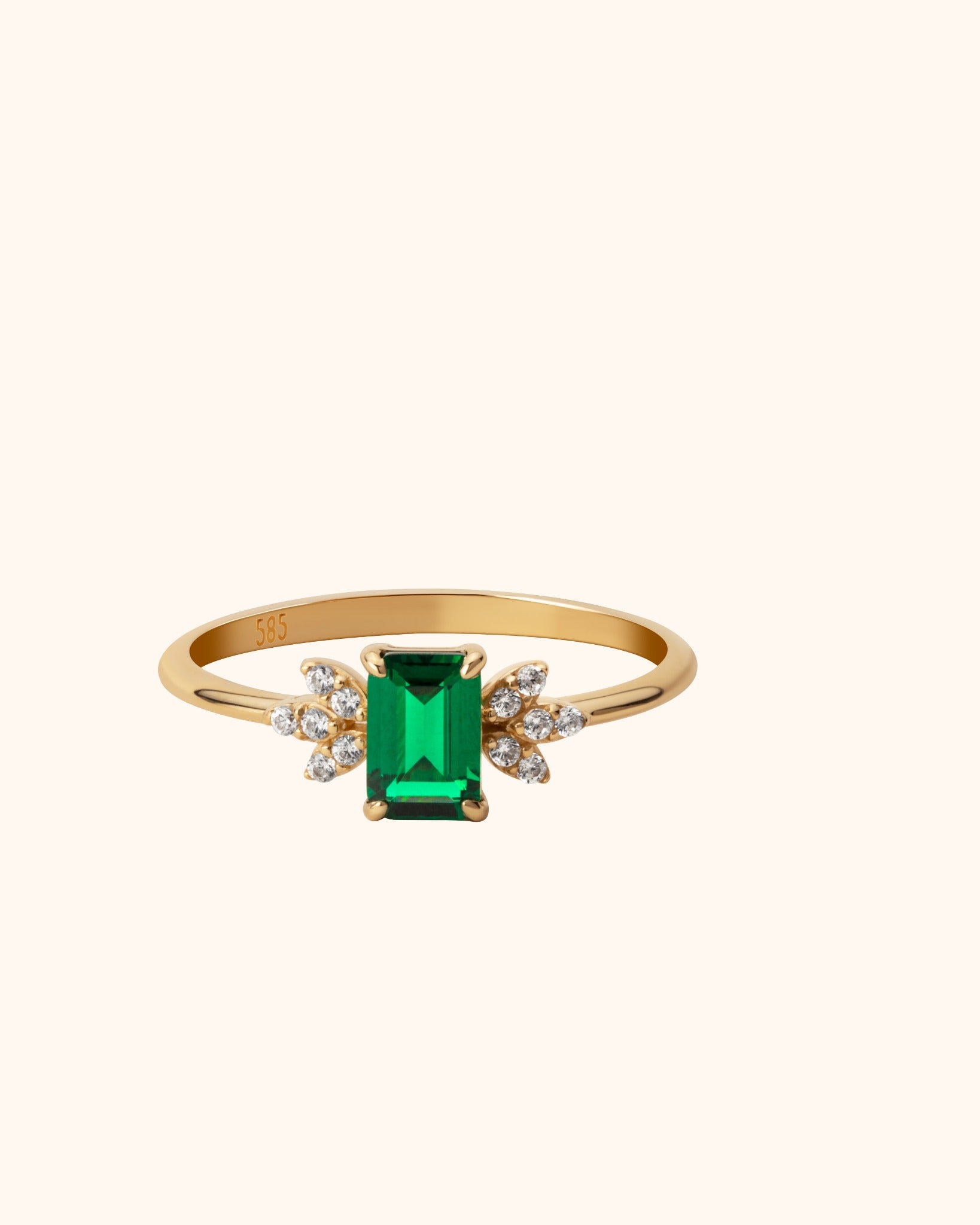 Elegant 14K gold ring with emerald-cut green gemstone and diamond floral side clusters