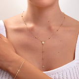 Model wearing a 3-piece 14K gold plated faith jewelry set with rosary necklace, cross bracelet, and matching earrings

