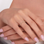 Frontal close-up of a woman’s hands showing a 14K gold zigzag ring with pavé-set white stones, styled in a modern and elegant look.