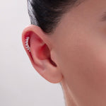 Curved gold helix piercing with baguette-cut zircon crystals – stylish cartilage cuff