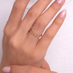 Close-up of woman's hand wearing a gold eternity ring with full-circle round stones