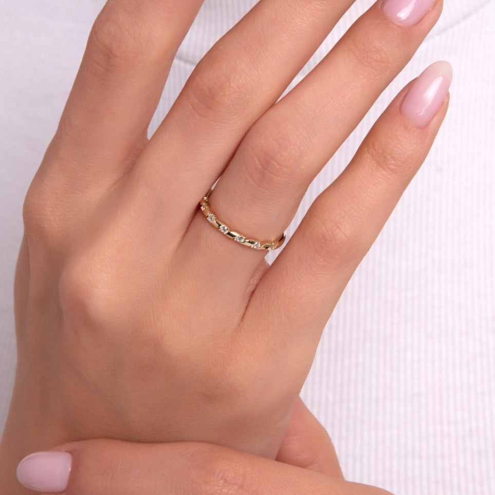 Close-up of woman's hand wearing a gold eternity ring with full-circle round stones