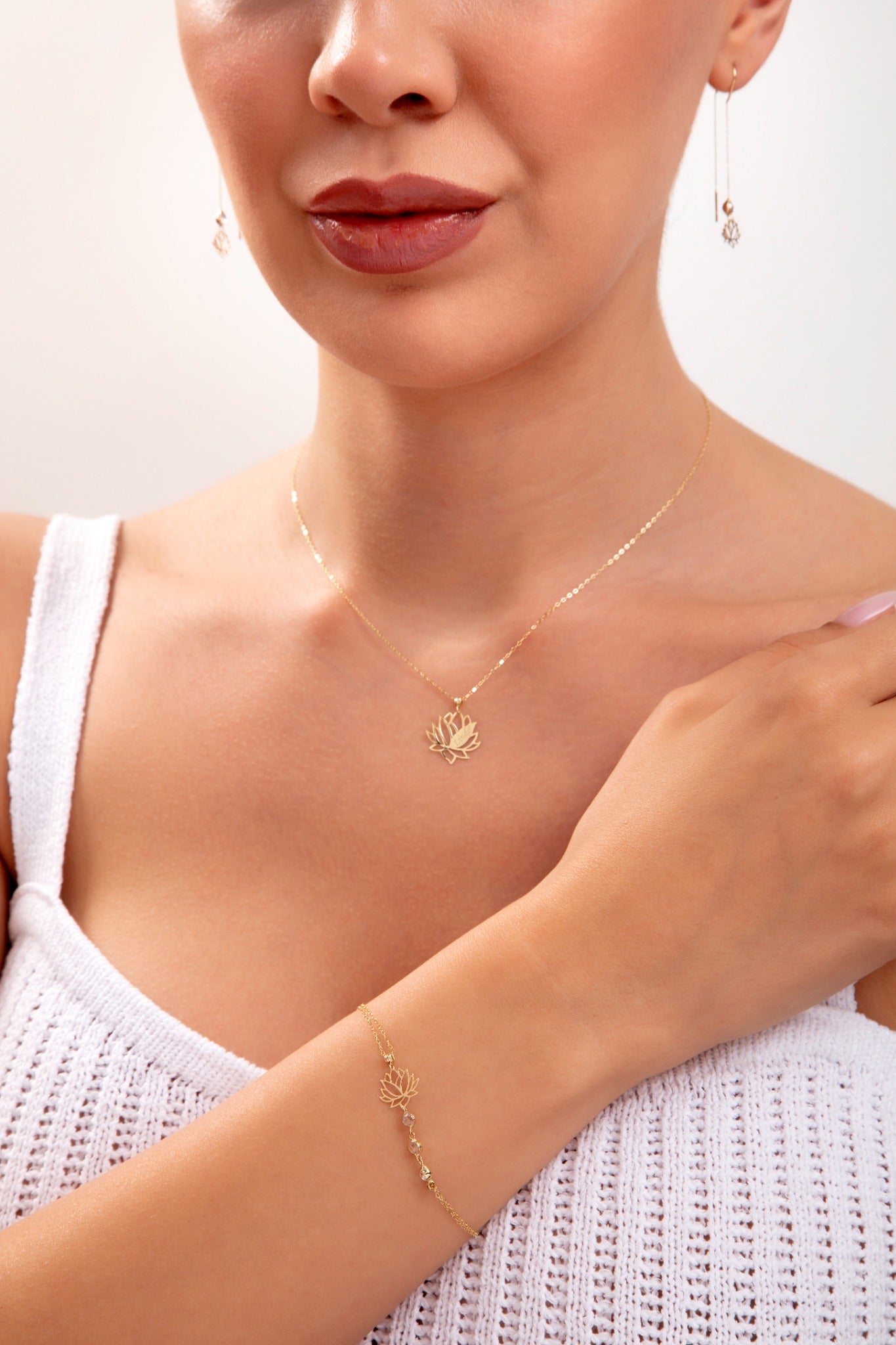 Model wearing a 14K gold plated lotus jewelry set including necklace, bracelet with crystals, and lotus threader earrings

