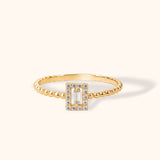 14K gold beaded ring with baguette-cut center stone and diamond halo