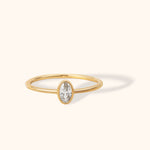 Minimalist 14K gold ring with oval white sapphire bezel setting