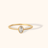 Minimalist 14K gold ring with oval white sapphire bezel setting