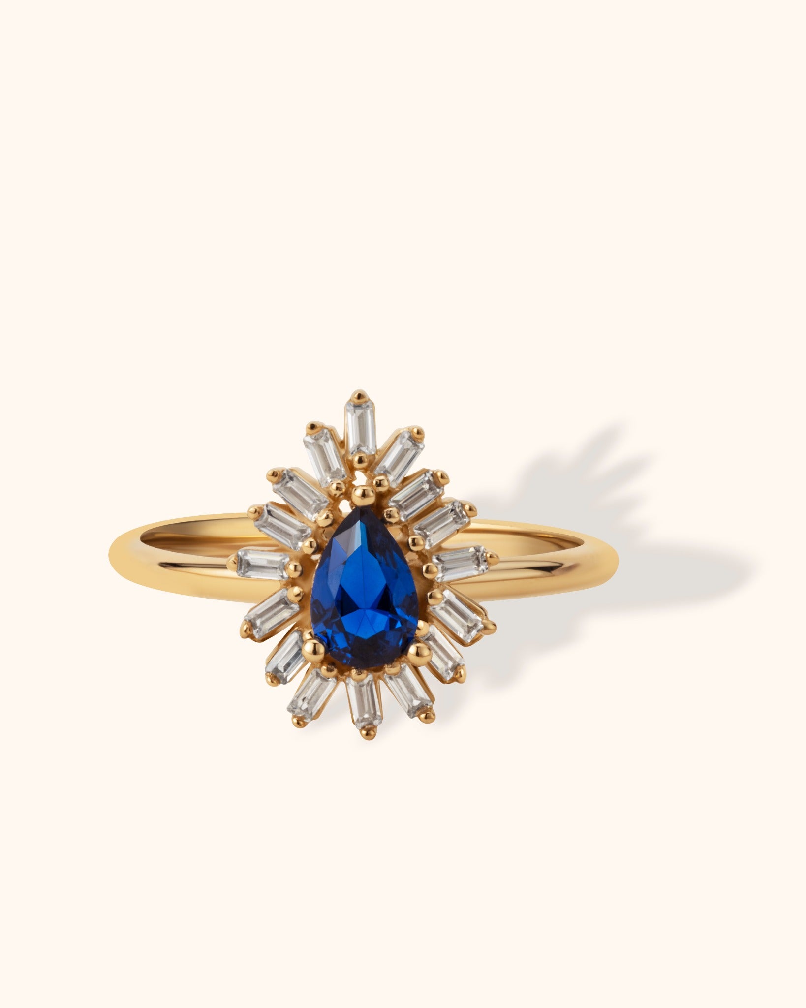 14K gold ring with pear-shaped blue sapphire and surrounding baguette diamonds