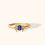 Bold 14K gold ring with deep blue sapphire center and diamond-accented spike details