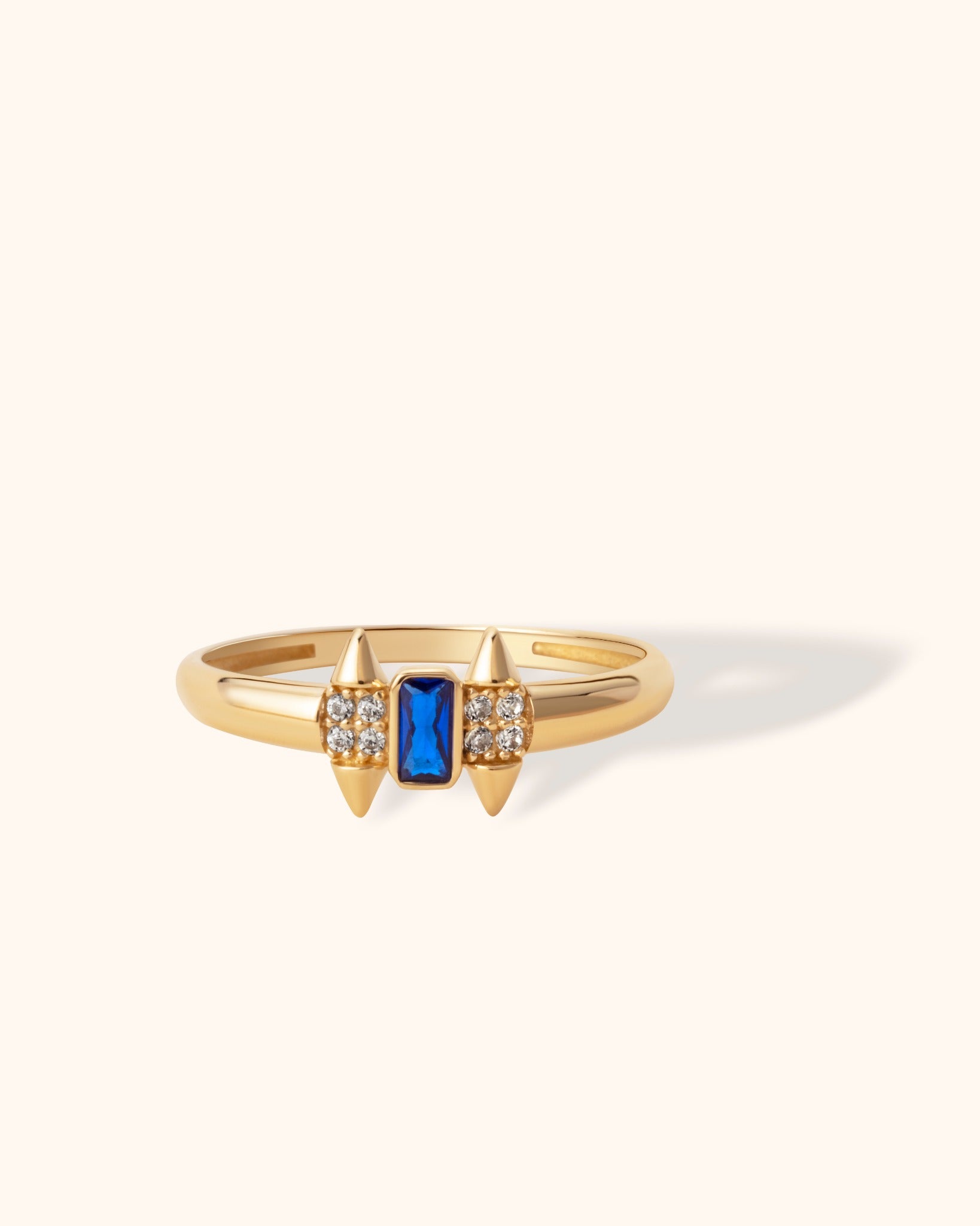 Bold 14K gold ring with deep blue sapphire center and diamond-accented spike details