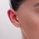 Model wearing a 14K Gold Pear-Cut CZ Tragus Stud – A minimalist teardrop-shaped cubic zirconia cartilage piercing, perfect for tragus or conch placements.