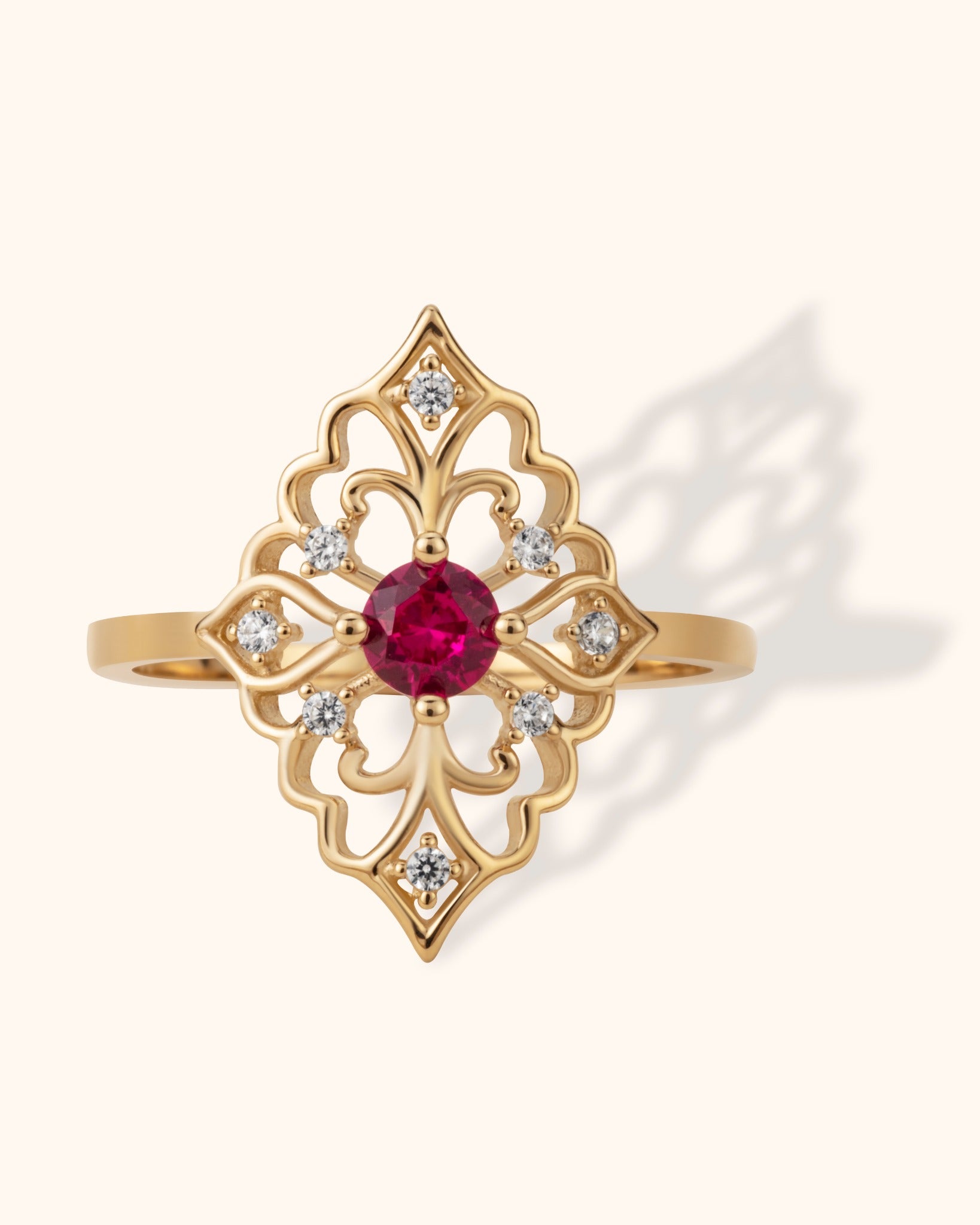 Intricate filigree ring in 14K gold featuring a round ruby center and surrounding diamonds