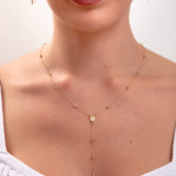 Model wearing a 14K gold plated rosary-style necklace with cross drop and Virgin Mary charm, plus matching threader earrings