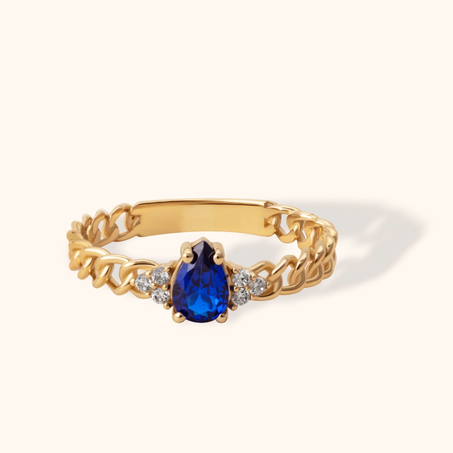 14K gold chain-style ring with pear-shaped deep blue sapphire and accent diamonds