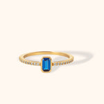 Emerald-cut sapphire gemstone ring set in 14K yellow gold with pavé zircon accents along the band.