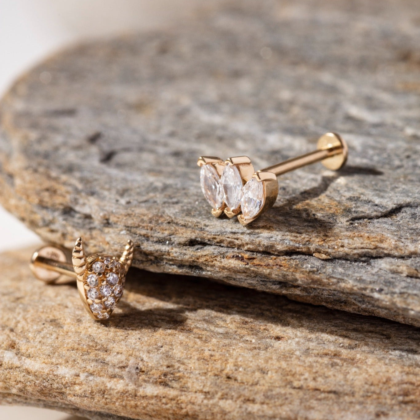 Set of three 14K gold tragus studs featuring a marquise-cut triple CZ cluster, a pavé horned shield stud, and a four-stone CZ cluster – Dainty cartilage earrings perfect for stacking in tragus, helix, or conch piercings