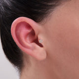 Model wearing a 14K Gold CZ Snow Flower Tragus Stud – Delicate floral-shaped cartilage piercing with clustered cubic zirconia, perfect for tragus or helix placements