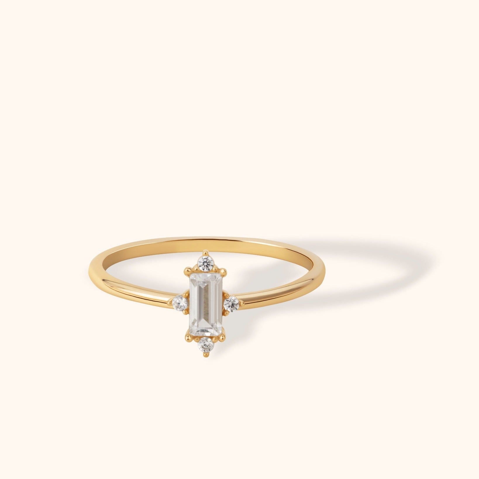 14K gold ring with vertical baguette-cut center and four diamond accents in starburst design