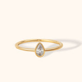 A minimalist treasure with maximum charm. This 14K gold teardrop solitaire ring features a bezel-set pear-cut ston