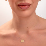 model wearing personalized initial necklace with two gold discs