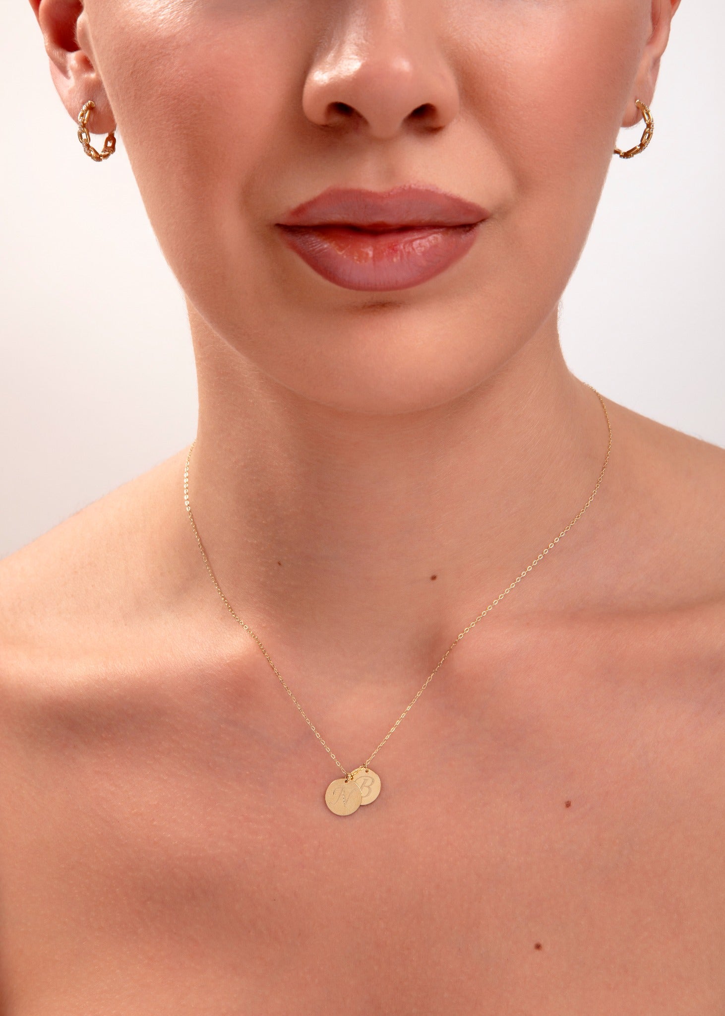 model wearing personalized initial necklace with two gold discs
