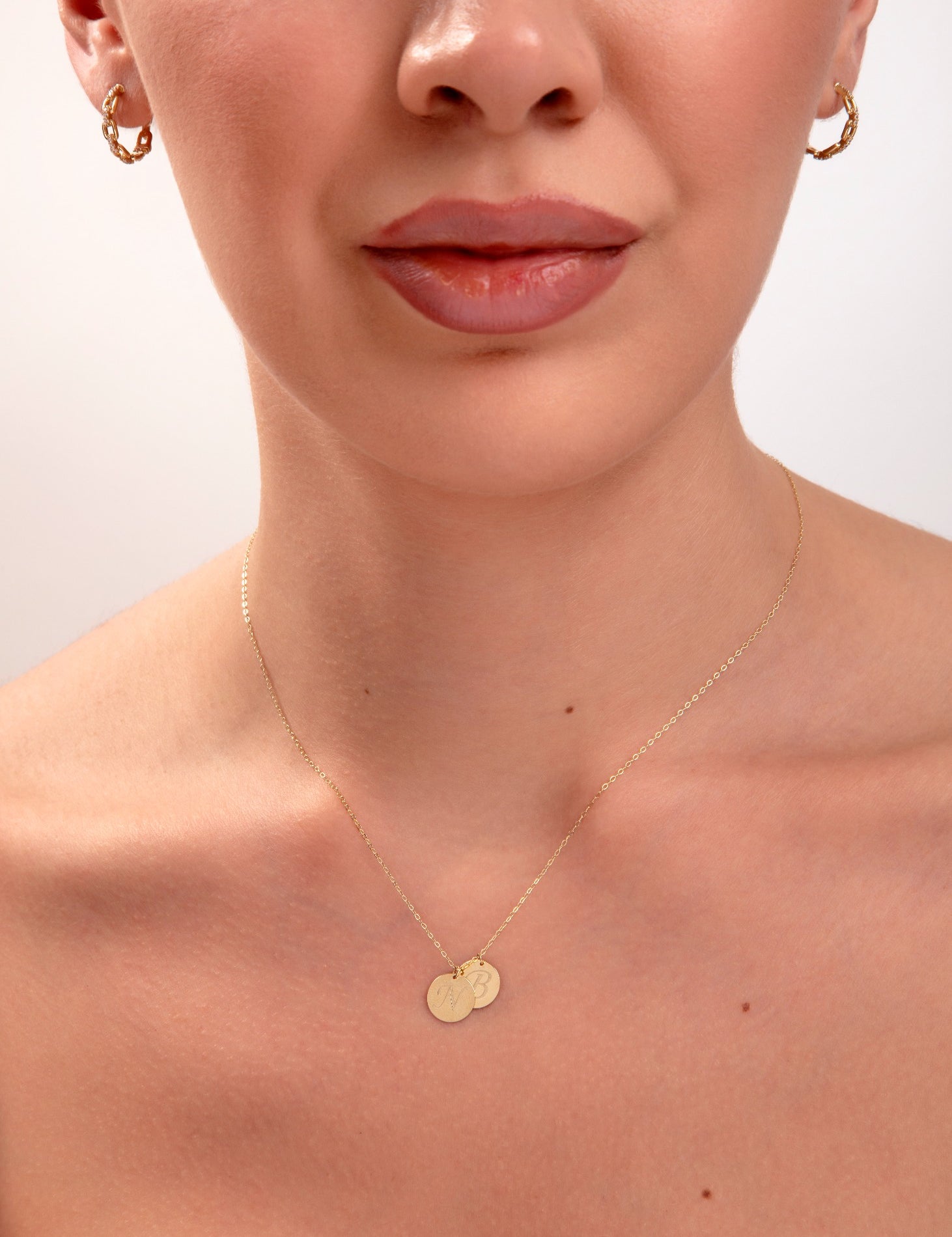model wearing personalized initial necklace with two gold discs