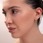 model wearing full gold jewelry set including necklace, bracelet, and two earring styles

